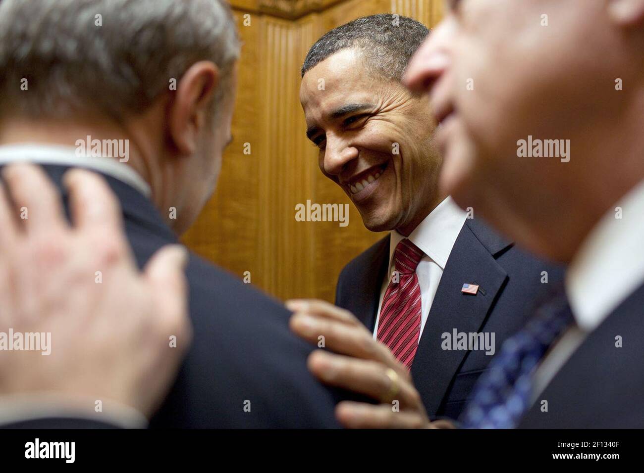 Präsident Barack Obama und Vizepräsident Joe Biden gratulieren Phil Schiliro, dem Assistenten des Präsidenten für Legislative Angelegenheiten, zur Verabschiedung des Gesetzes zur Gesundheitsreform, während sie am 21. März 2010 mit dem Aufzug zur Residenz des Weißen Hauses fahren. Stockfoto