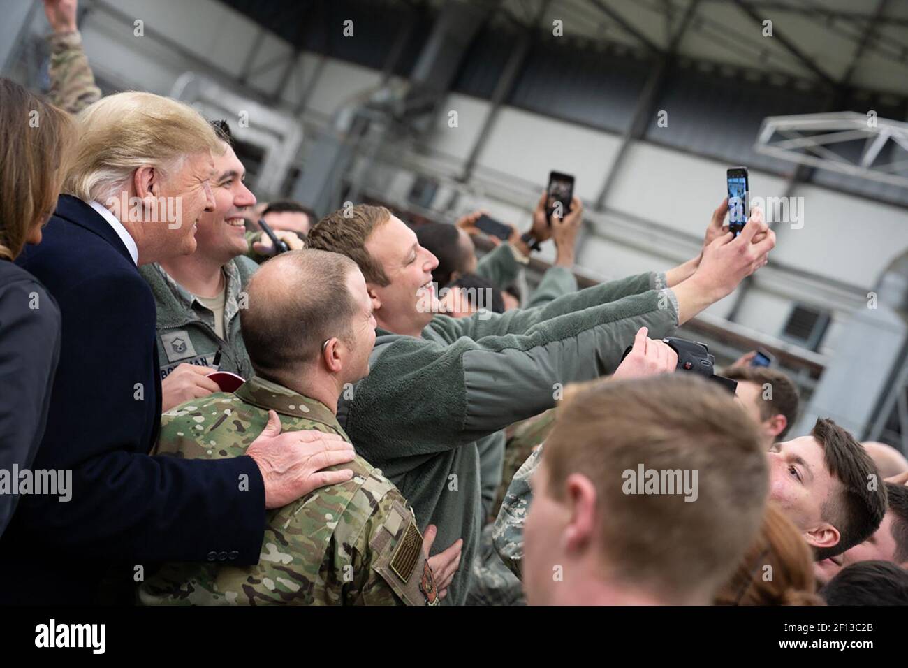 Präsident Donald Trump schüttelt sich die Hände und fotografiert mit Militärs während eines Zwischenstopps auf dem Luftwaffenstützpunkt Ramstein in Deutschland am Mittwochabend, dem 26 2018. Dezember, nach seinem unangekündigten Besuch bei US-Truppen auf dem Luftwaffenstützpunkt Al-Asad im Irak. Stockfoto