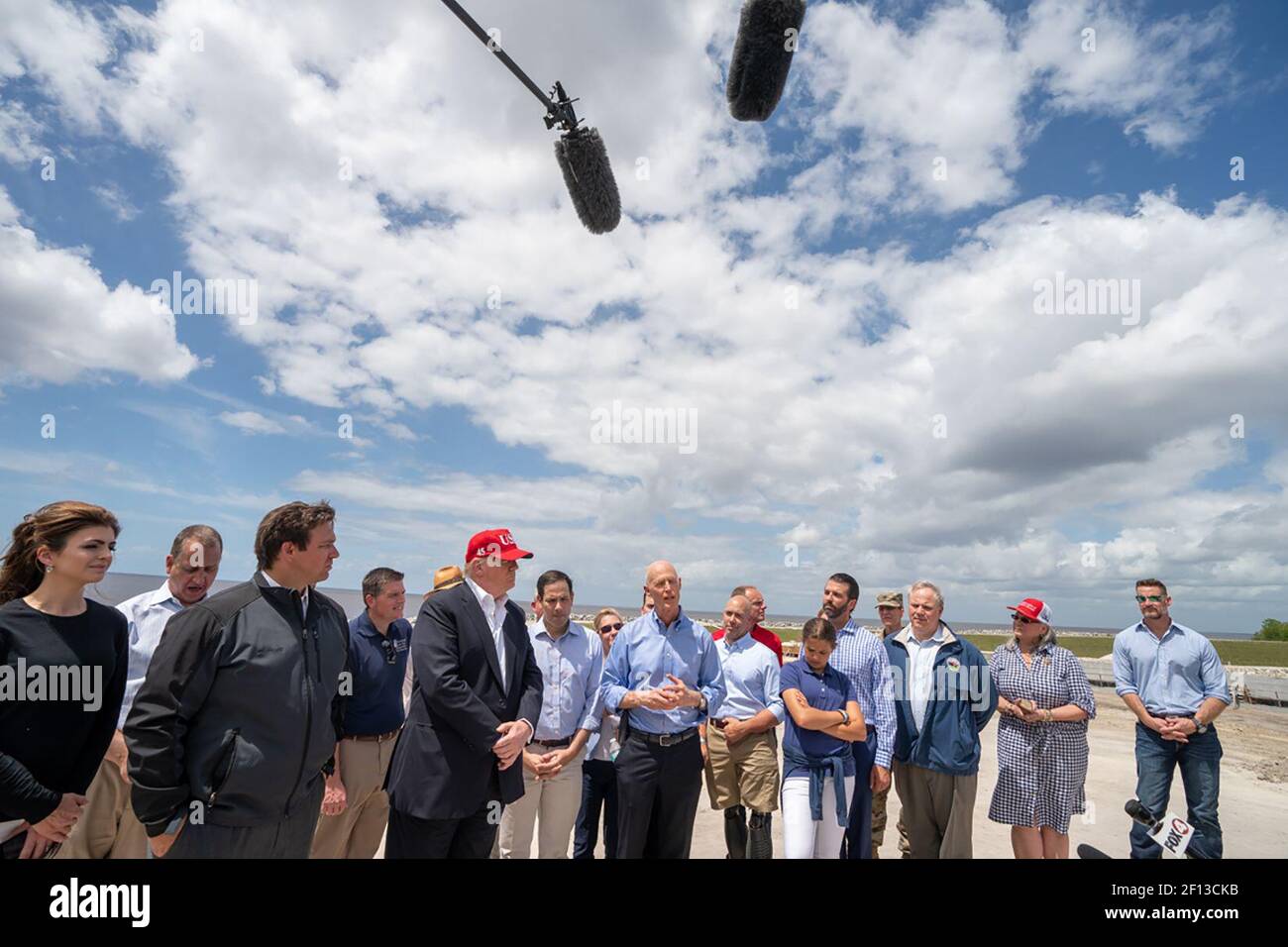 Präsident Donald Trump hört als Senator Rick Scott R-Fla. Adressen seine Bemerkungen Freitag März 29 2019 während Präsident Trumps Besuch auf der 143-Meilen Herbert Hoover Dyke in Lake Okeechobee Fla. Der Deich, der Okeechobeesee umgibt ist Teil der Kissimmee-Okeechobee Everglades System, das Auswirkungen von Überschwemmungen für Gebiete reduziert Von Süd-Florida. Stockfoto