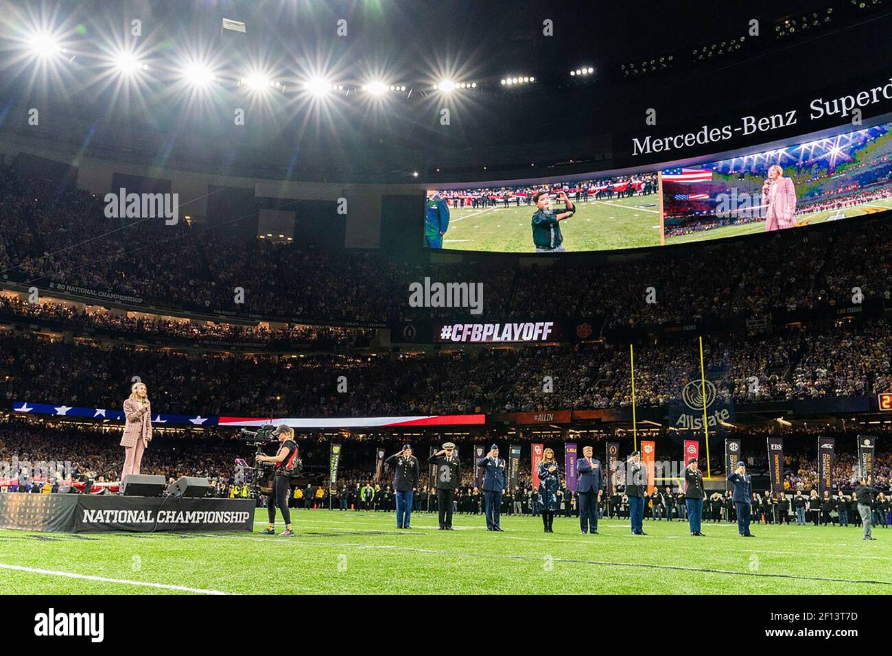 Präsident Donald Trump und First Lady Melania Trump legen ihre Hände auf ihr Herz, während Lauren Daigle die Nationalhymne bei der College Football Playoff National Championship zwischen der Clemson University und der Louisiana State University am Montag, 13 2020. Januar, im Mercedes-Benz Superdome in New Orleans singt. Stockfoto