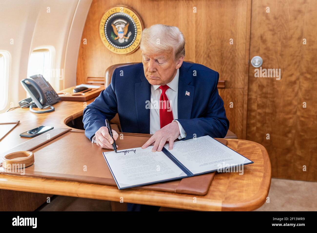 Präsident Donald Trump unterzeichnet einen Executive Order, der die Behörde gemäß dem Defense Production Act an den Chief Executive Officer der United States International Development Finance Corporation delegiert, um auf den COVID-19 Ausbruch am Donnerstag, den 14 2020. Mai an Bord der Air Force One auf dem Weg zum Lehigh Valley International Airport in Allentown zu reagieren Pa. Stockfoto