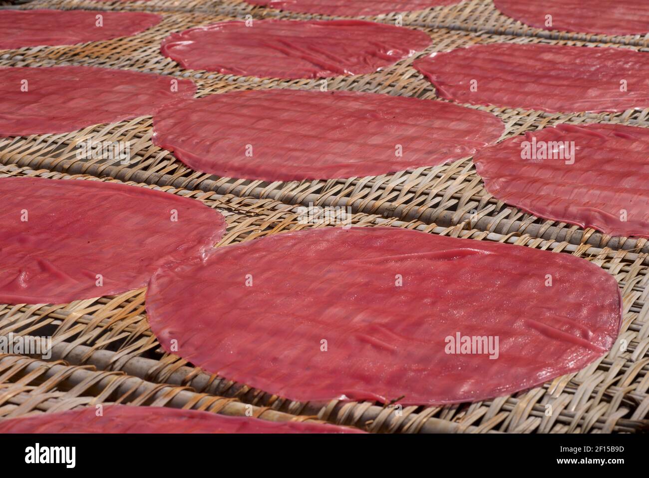 Farbige Reispapier Crepes ausgelegt, um auf Rattan Matten in der Sonne zu trocknen. Can Tho, Mekong Delta, Vietnam Stockfoto
