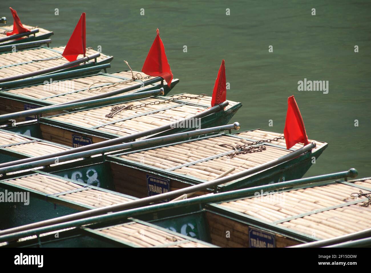 Boote Reihen sich auf dem Flussufer, bereit für touristische Ausflüge rund um die Trang an Scenic Landscape Complex, Ninh Binh, Vietnam Stockfoto