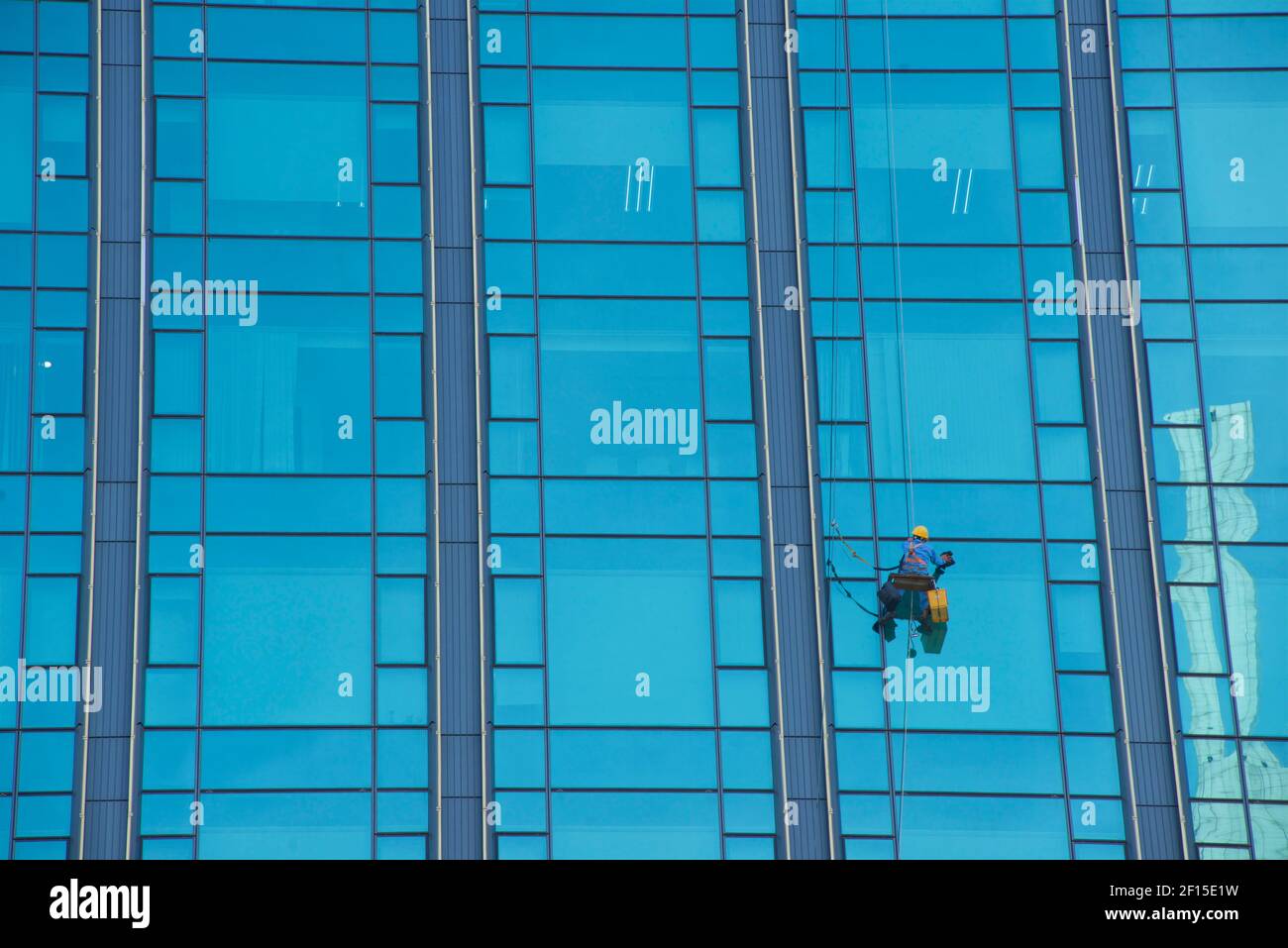Absailing Fensterputzer Reinigung Fenster auf einem blauen Glas Wolkenkratzer, Ho Chi Minh City, Vietnam. Stockfoto