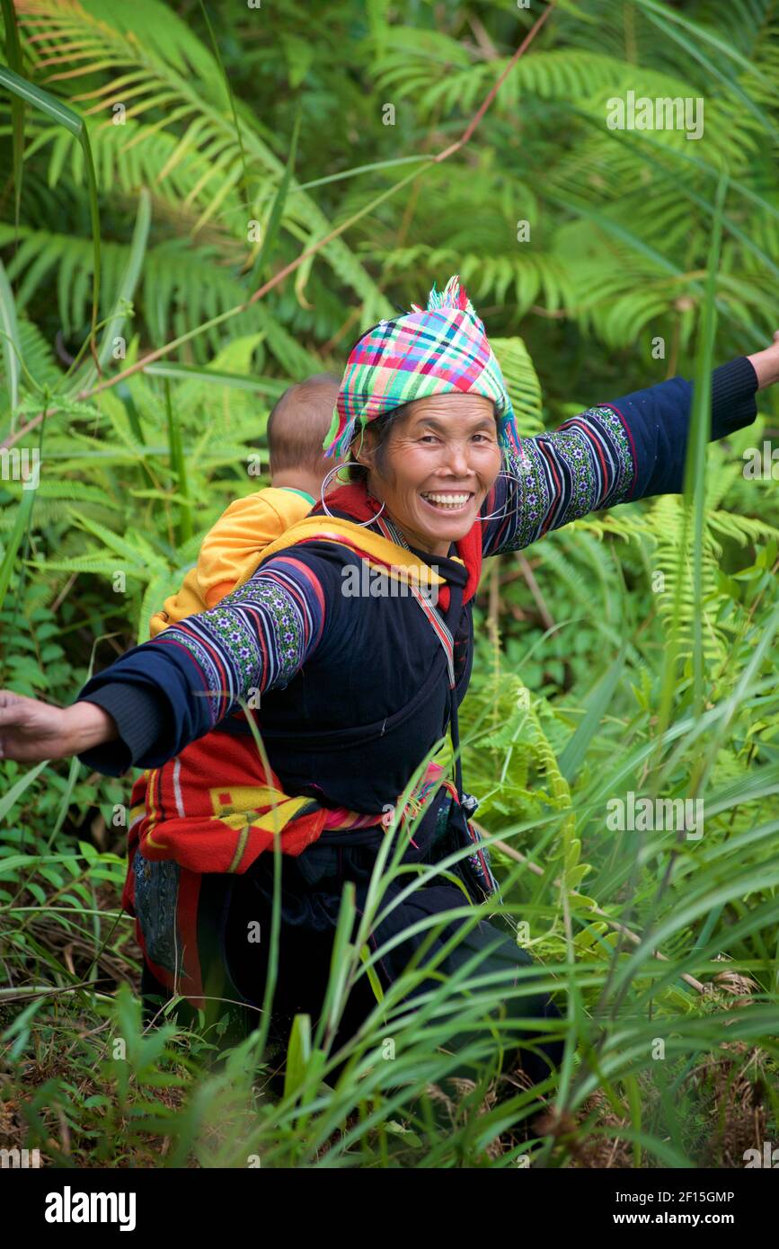 Vietnamesische Frau, die Kind auf dem Rücken trägt, Sapa, Provinz Lao Cai, Nordvietnam. Hmong Hilltribe. Stockfoto