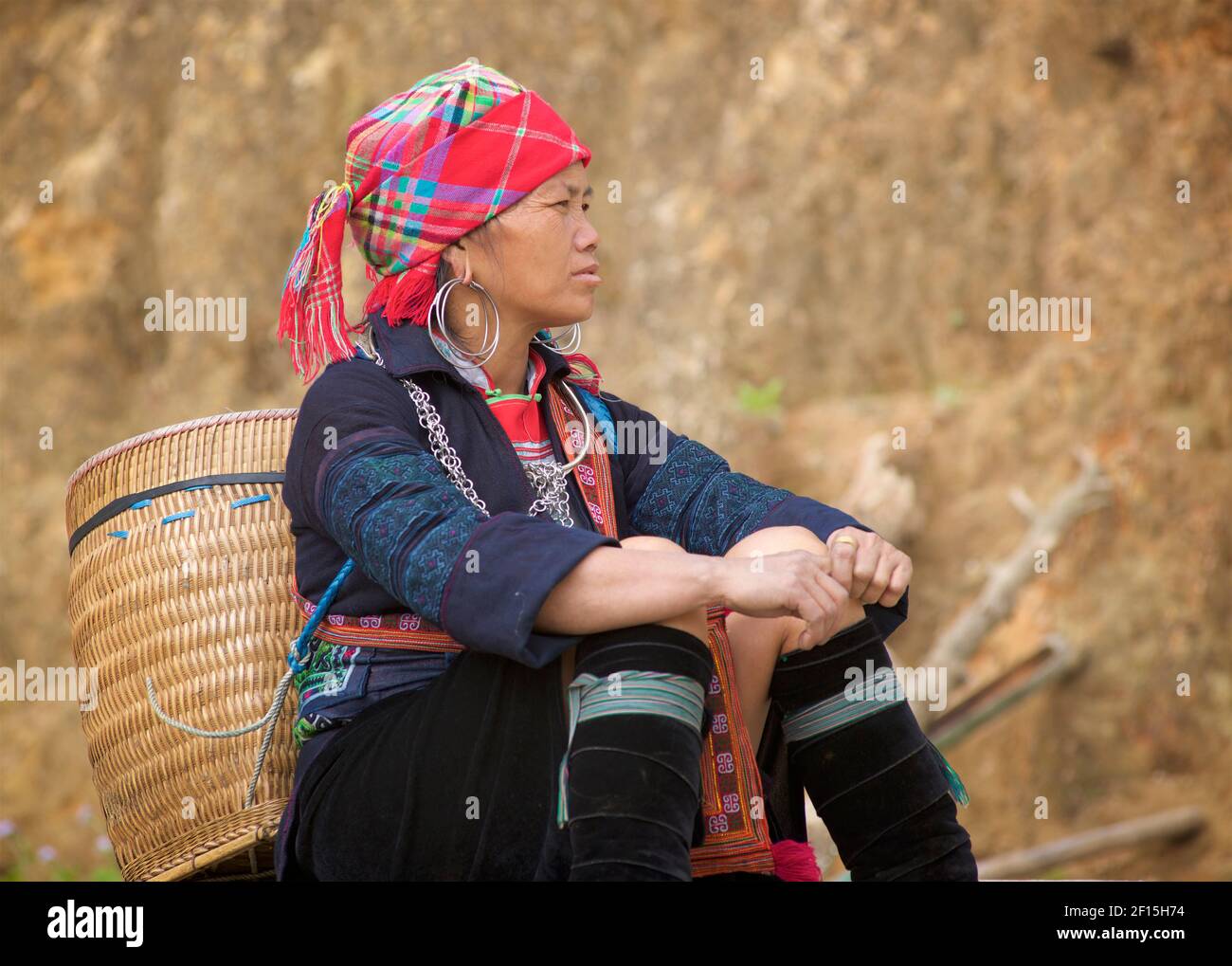 Hmong Frau sitzend, mit geflochtenem Rattankorb. Sapa Gebiet, Lao Cai Provinz, Nordvietnam Stockfoto