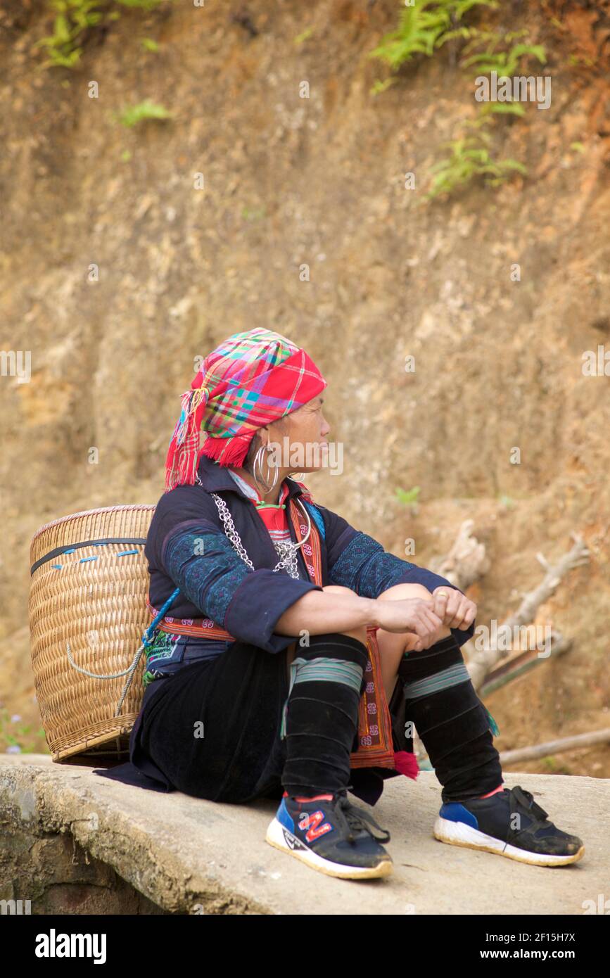 Hmong Frau sitzend, mit geflochtenem Rattankorb. Sapa Gebiet, Lao Cai Provinz, Nordvietnam Stockfoto