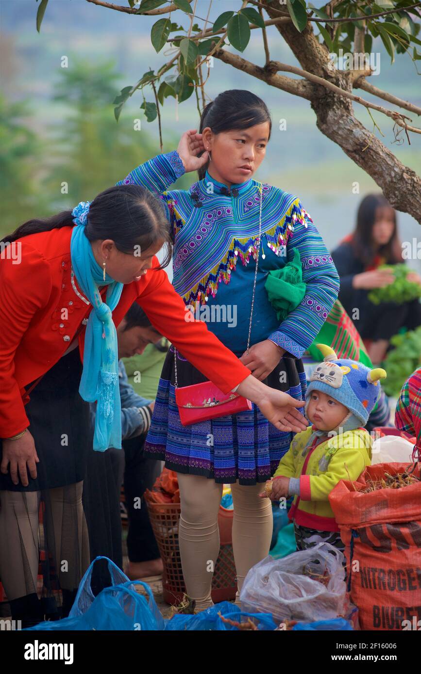 Blume Hmong Frau streichelte Kleinkinder Wangen auf Bac Ha Markt, Lao Cai Provinz, Stockfoto