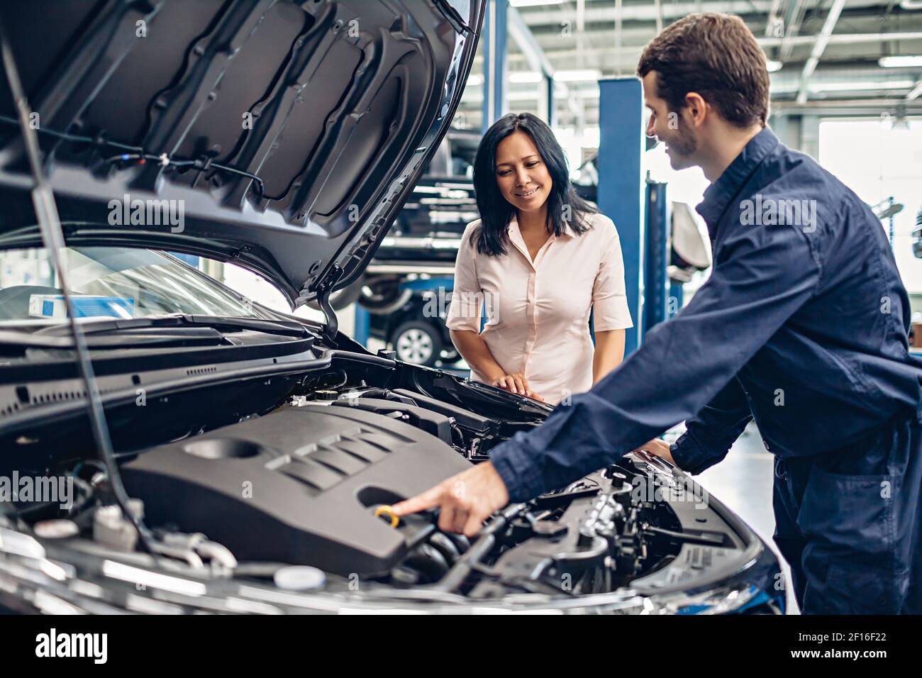 Car Service Center Szene. Der Mechaniker kommuniziert mit dem Kunden Stockfoto