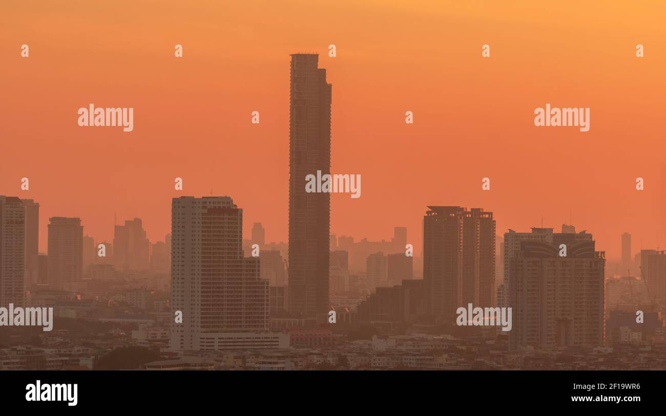 Luftverschmutzung. Smog und feiner Staub von pm2.5 bedeckt Stadt am Morgen mit orange Sonnenaufgangshimmel. Stadtbild mit verschmutzter Luft. Schmutzige Umgebung. Stadt Stockfoto