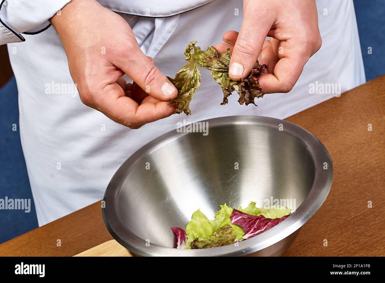 Hände hinzufügen Salatblätter in Schüssel mit Salat, close-up Stockfoto