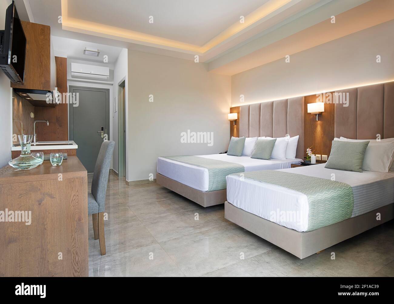 Moderne Wohnung Interieur des Schlafzimmers mit Eichenholzmöbeln, Einzel-, Doppel-Kingsize-Bett, weichen grauen Textil-Kopfteil. Modernes Familienstudio Stockfoto