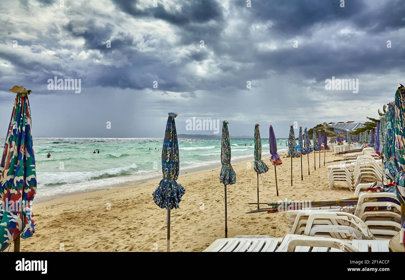 Sonnenschirme und Chaiselongues vor dem Sturm gefaltet Stockfoto