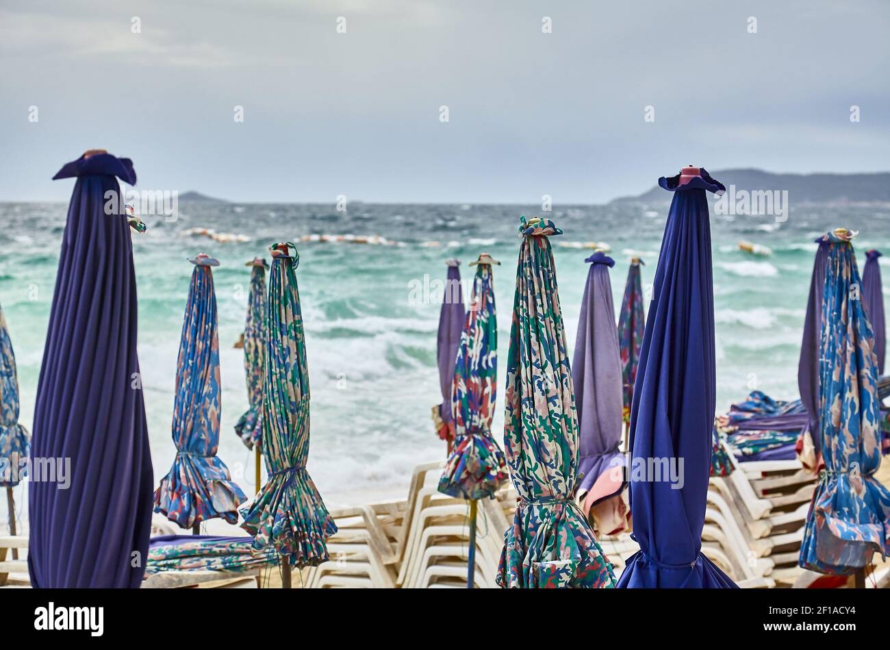 Sonnenschirme und Chaiselongues vor dem Sturm gefaltet Stockfoto