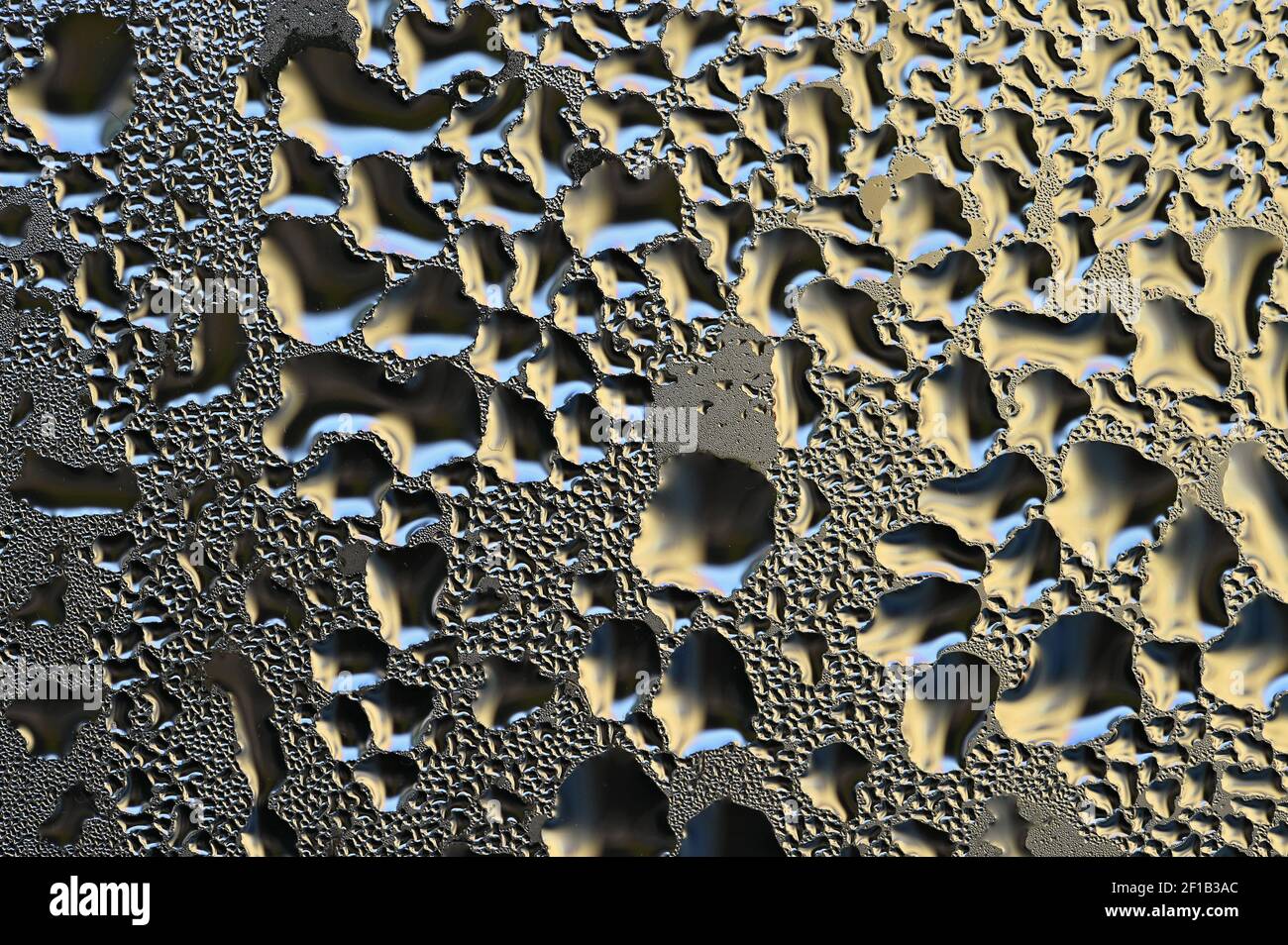 Farbenfroher abstrakter Hintergrund. Schöne Makroaufnahme von Wassertropfen auf einem Fenster. Stockfoto