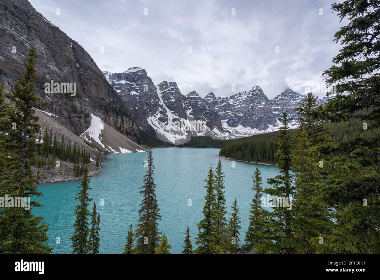 Blick auf den wunderschönen alpinen See mit türkisfarbenem Wasser, umgeben von herrlichen Gipfeln, hochperspektivisch aufgenommen an einem bewölkten Tag am Moraine Lake Stockfoto