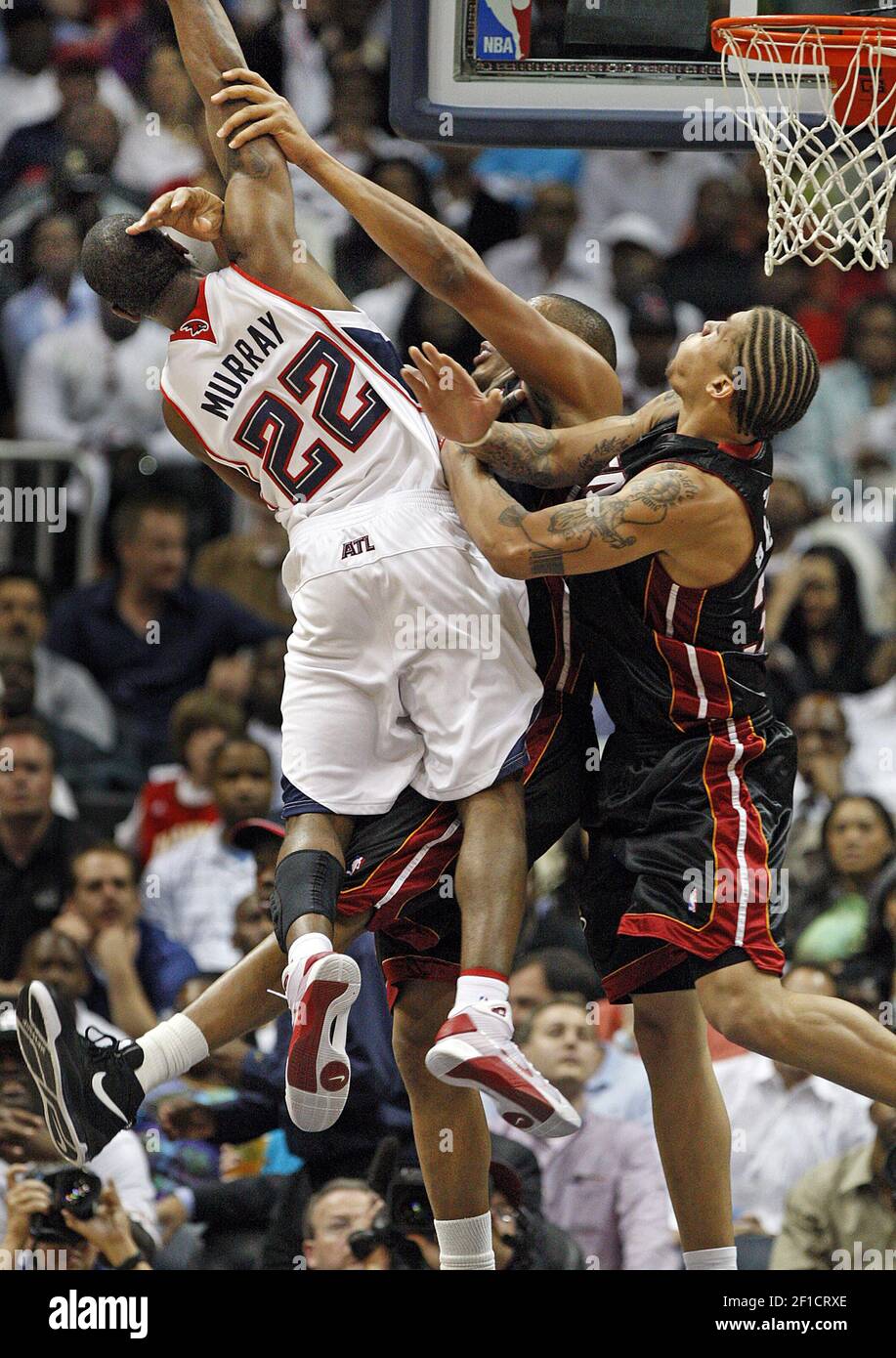 Atlanta Hawks Wache Flip Murray (22) nimmt eine harte Foul von Miami Heat Center Jamaal Magloire, Mitte, und vorwärts Michael Beasley, rechts, während seccond halb Aktion in Spiel 2 der Eastern Conference Viertelfinale in der Philips Arena in Atlanta, Georgia, Mittwoch, 22. April 2009. Die Hitze besiegte die Hawks, 108-93. (Foto von Curtis Compton/Atlanta Journal-Constitution/MCT/Sipa USA) Stockfoto