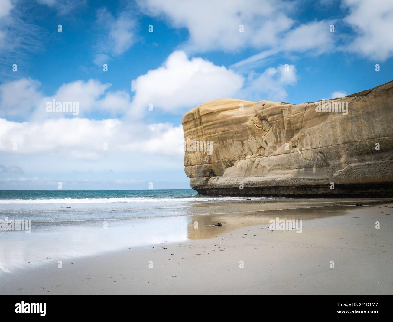 Meereslandschaft mit blauem Himmel und Sandsteinfelsen als Hauptthema. Aufgenommen am Tunnel Beach, Dunedin, Otago Peninsula, Neuseeland Stockfoto