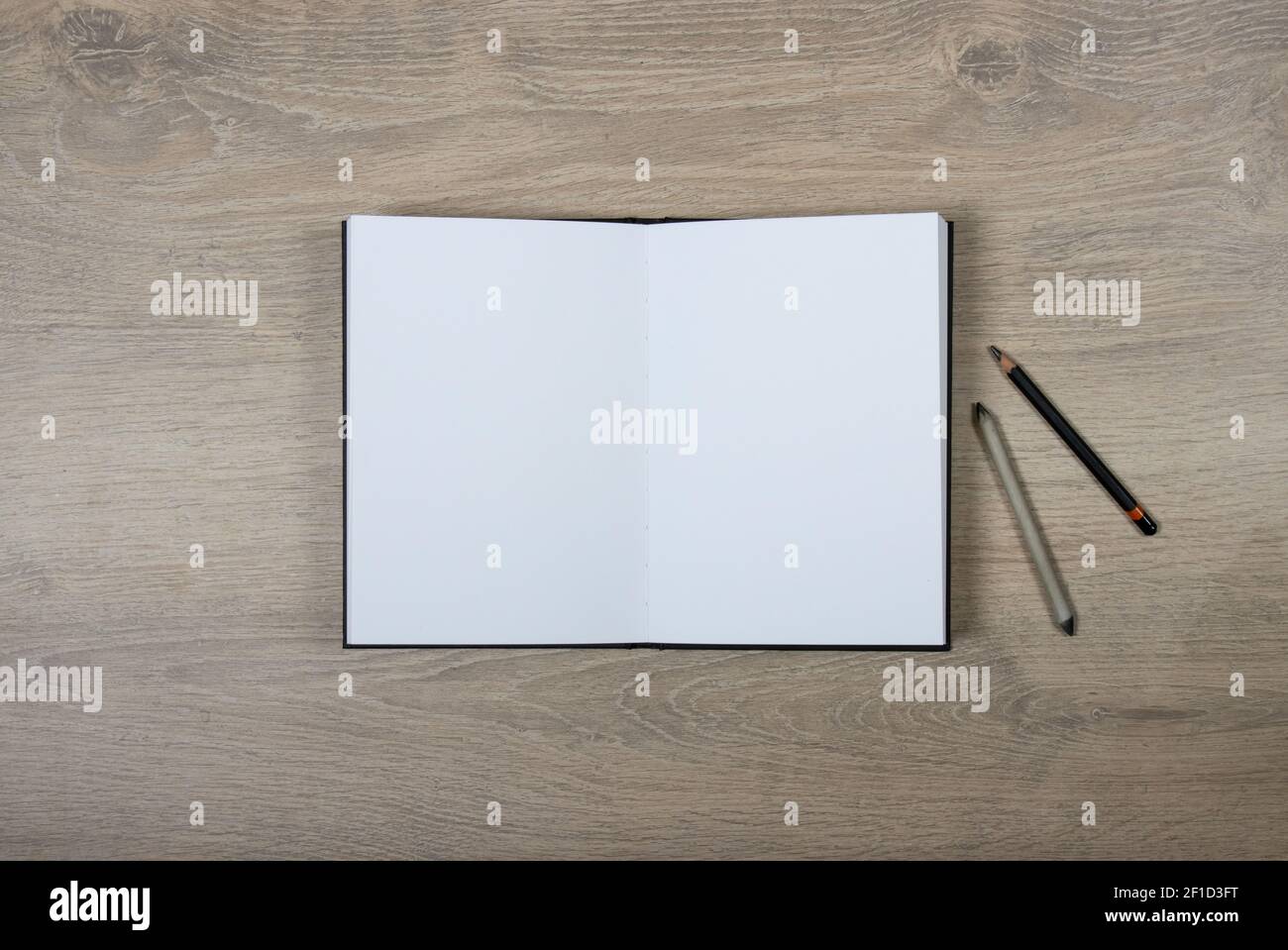 Skizzenbuch mit leeren Seiten auf Holzhintergrund öffnen Stockfoto