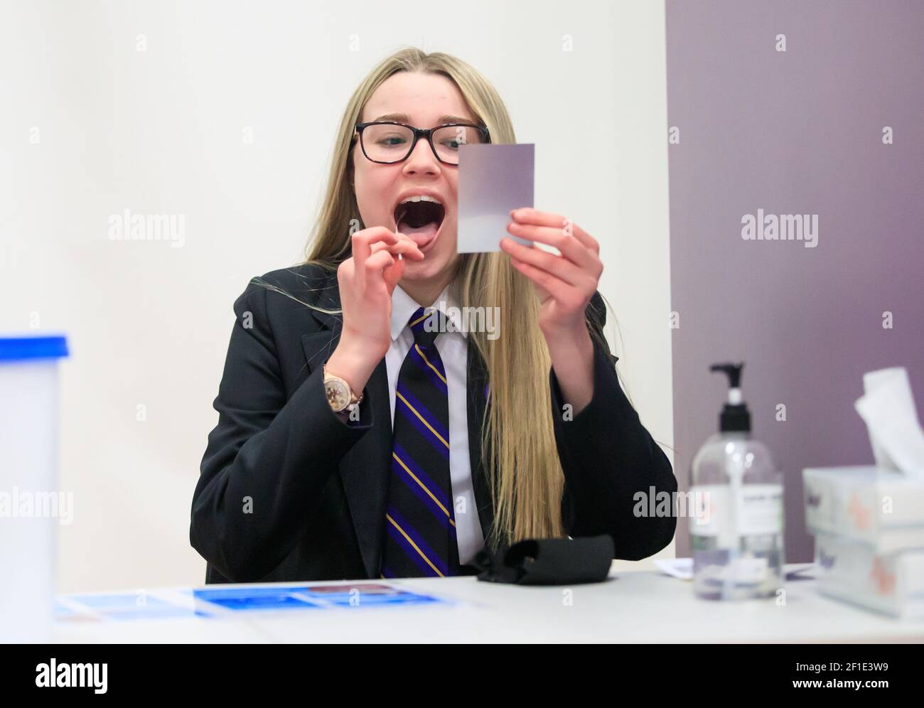 Erin Horn schaut in einen Spiegel, während er einen Lateral Flow Test macht, als Kinder in der Outwood Academy in Woodlands, Doncaster in Yorkshire, ankommen, während Schüler in England zum ersten Mal seit zwei Monaten im Rahmen der ersten Stufe der Lockerung zur Schule zurückkehren. Bilddatum: Montag, 8. März 2021. Stockfoto