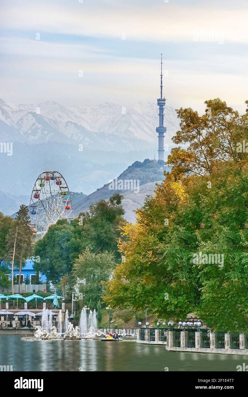 Blick auf den Kok Tobe Turm in Almaty, See und Riesenrad im Gorky Park, Kasachstan Stockfoto