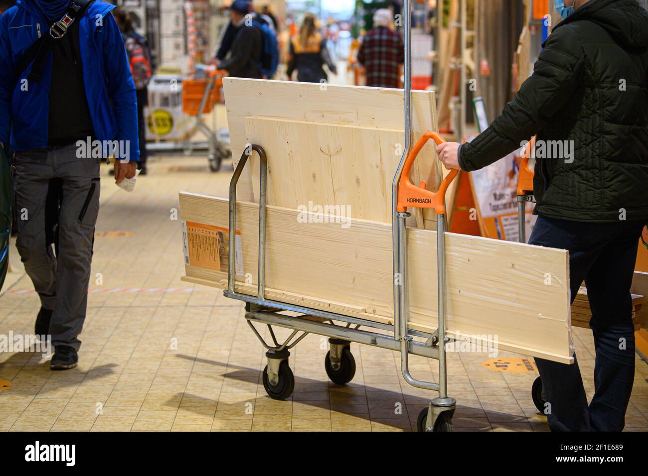 Dresden, Deutschland. März 2021, 08th. Ein Kunde schiebt einen beladenen Warenkorb in einem Hornbach-Baumarkt durch einen Gang. Ab heute dürfen Baumärkte in Sachsen nach wochenlanger Schließung aufgrund von Korona den Betrieb nach strengen Hygienevorschriften wieder aufnehmen. Quelle: Robert Michael/dpa-Zentralbild/dpa/Alamy Live News Stockfoto
