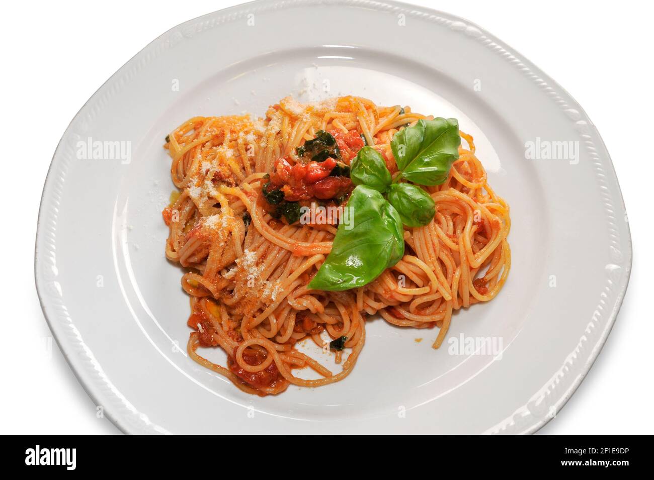 Spaghetti in Tomatensauce mit Basilikumblättern in der Platte isoliert auf weiß, Draufsicht, Nahaufnahme Stockfoto