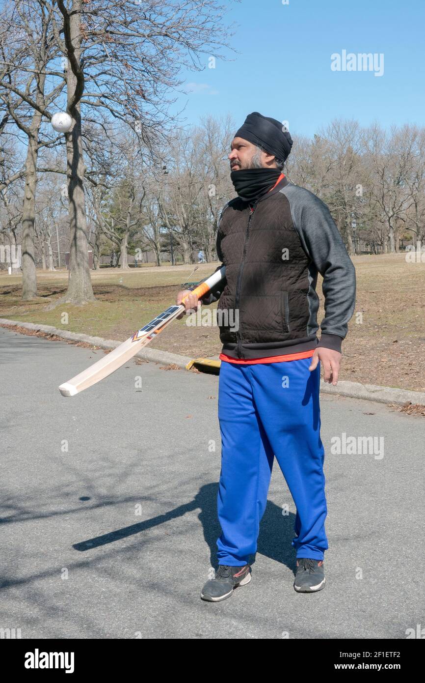 Ein Sikh New Yorker, ursprünglich aus Indien, erwärmt sich für ein Cricket-Spiel, indem er einen Ball in die Luft klopft. In Flushing Meadows Corona Park in Queens, New York. Stockfoto