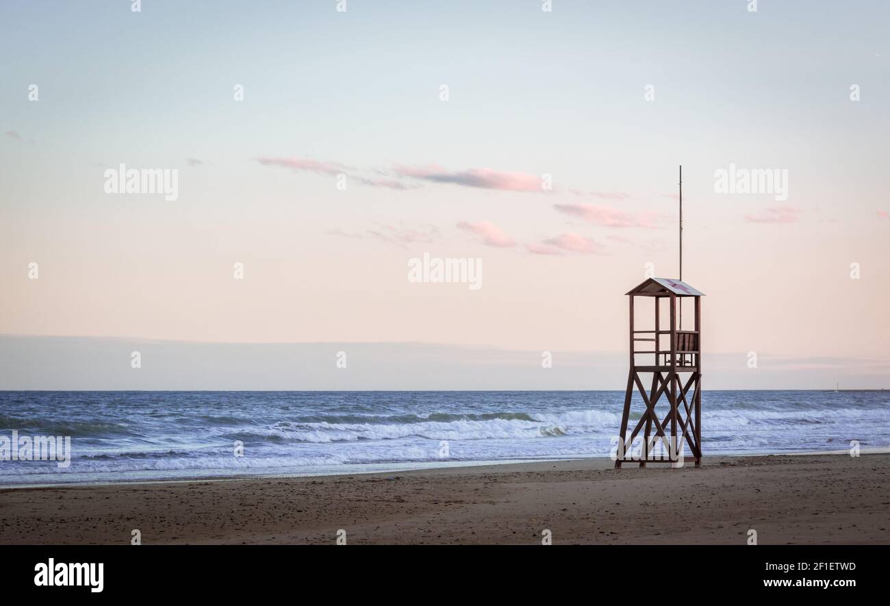 Sonnenaufgang am Strand mit vintage Rettungsschwimmer Holzturm Stockfoto