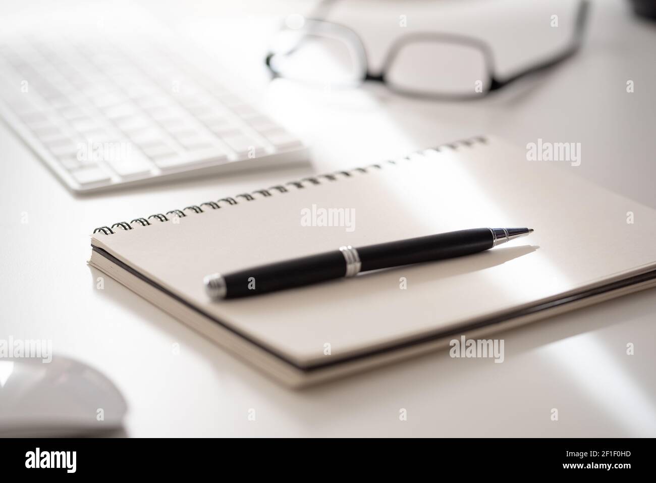 Nahaufnahme von Spiralnotizblock mit Kugelschreiber auf weißem Schreibtisch, Notizen machen Konzept Stockfoto