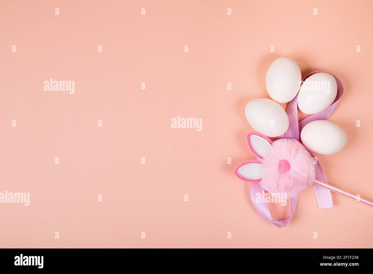 Ostern. Weiße Eier mit einem künstlichen Kaninchen auf einem gleichmäßigen rosa Hintergrund. Für Text platzieren. Stockfoto