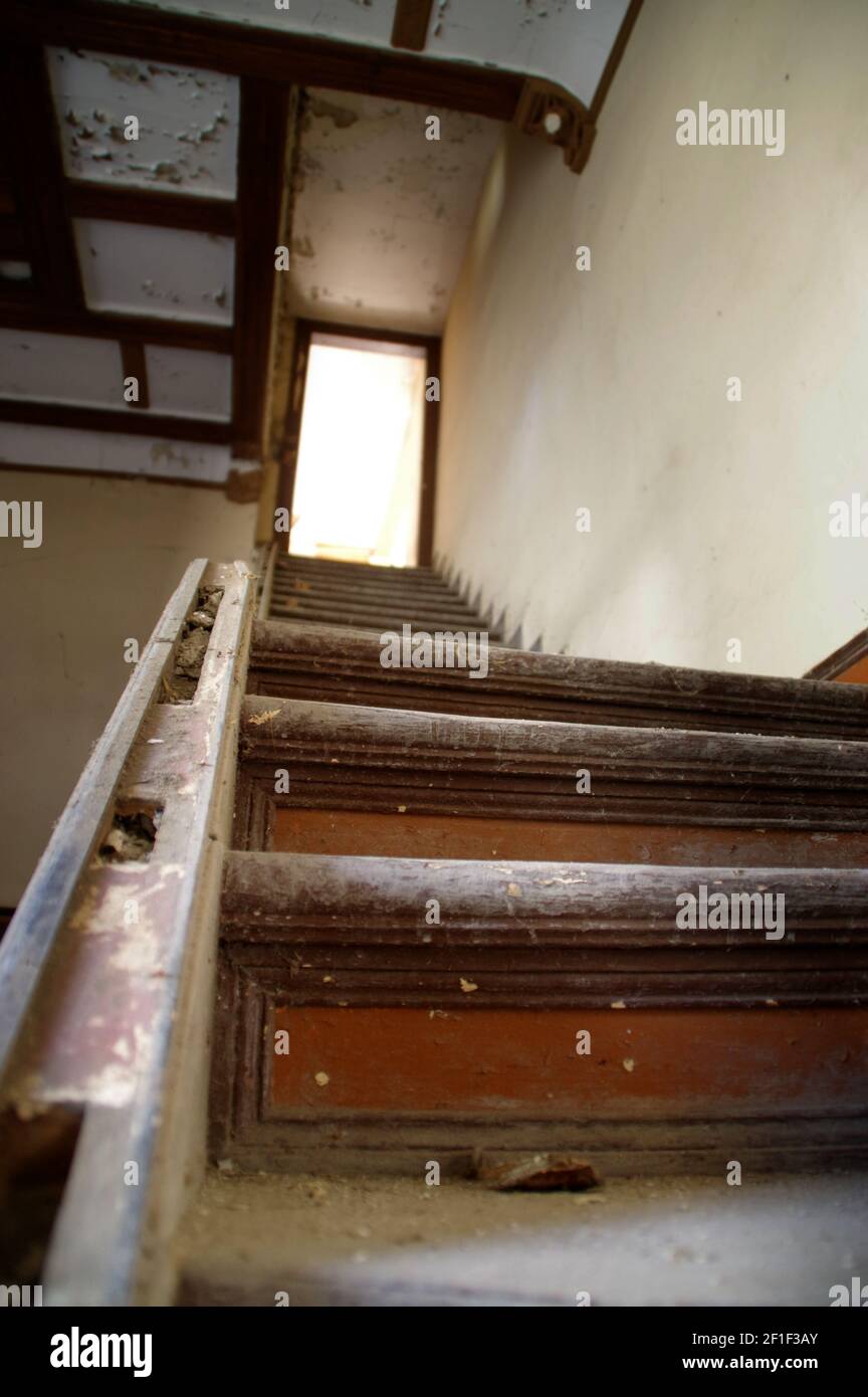 Ruinen des Gebäudes mit beschädigten Treppen. Alte verlassene Haus innen. Stockfoto