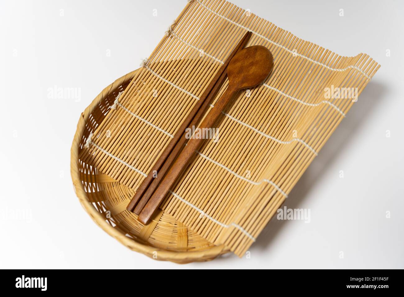 Holzbesteck, Essstäbchen aus Holz, Bambuskorb, Bambusmatte Stockfoto