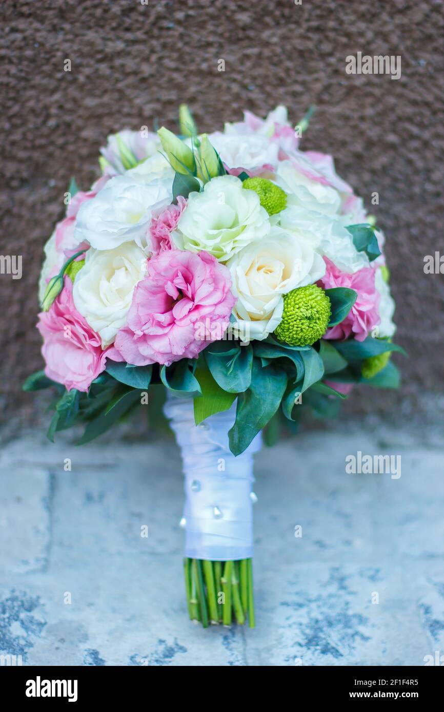 Hochzeit Bouquet von rosa Blumen, weißen Blumen und Grün ist auf dem braunen und grauen Hintergrund. Hochzeit Floristik. Stilvoller Strauß Rosen, Pfingstrosen Stockfoto