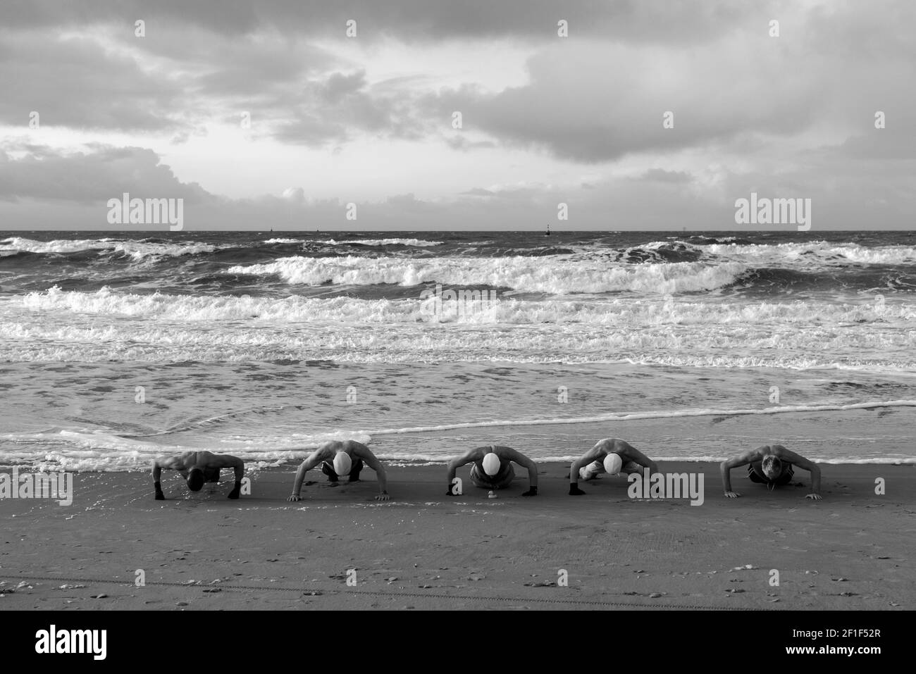 Eine Gruppe von Schwimmern trainieren, bevor sie das kalte Wasser des Meeres betreten. Stockfoto