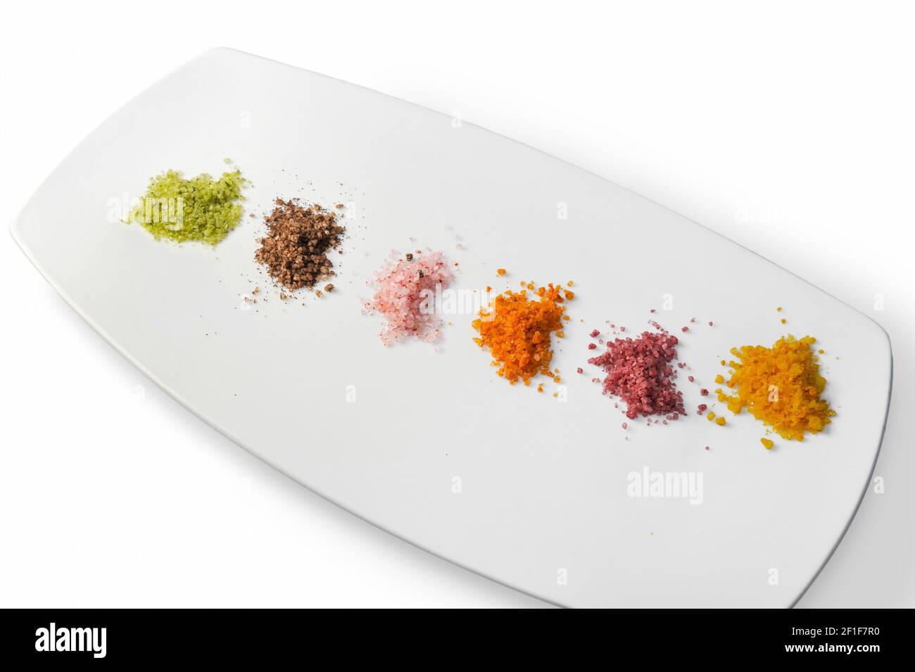 Buntes Meersalz, Palette von aromatisierten Salz Kochen auf Teller isoliert auf dem weißen Stockfoto