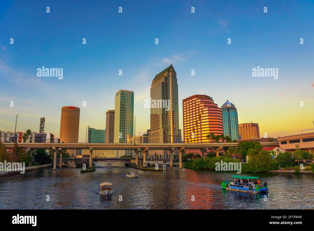 Skyline von Tampa bei Sonnenuntergang mit Touristenbooten auf dem Hillsborough Fluss Stockfoto