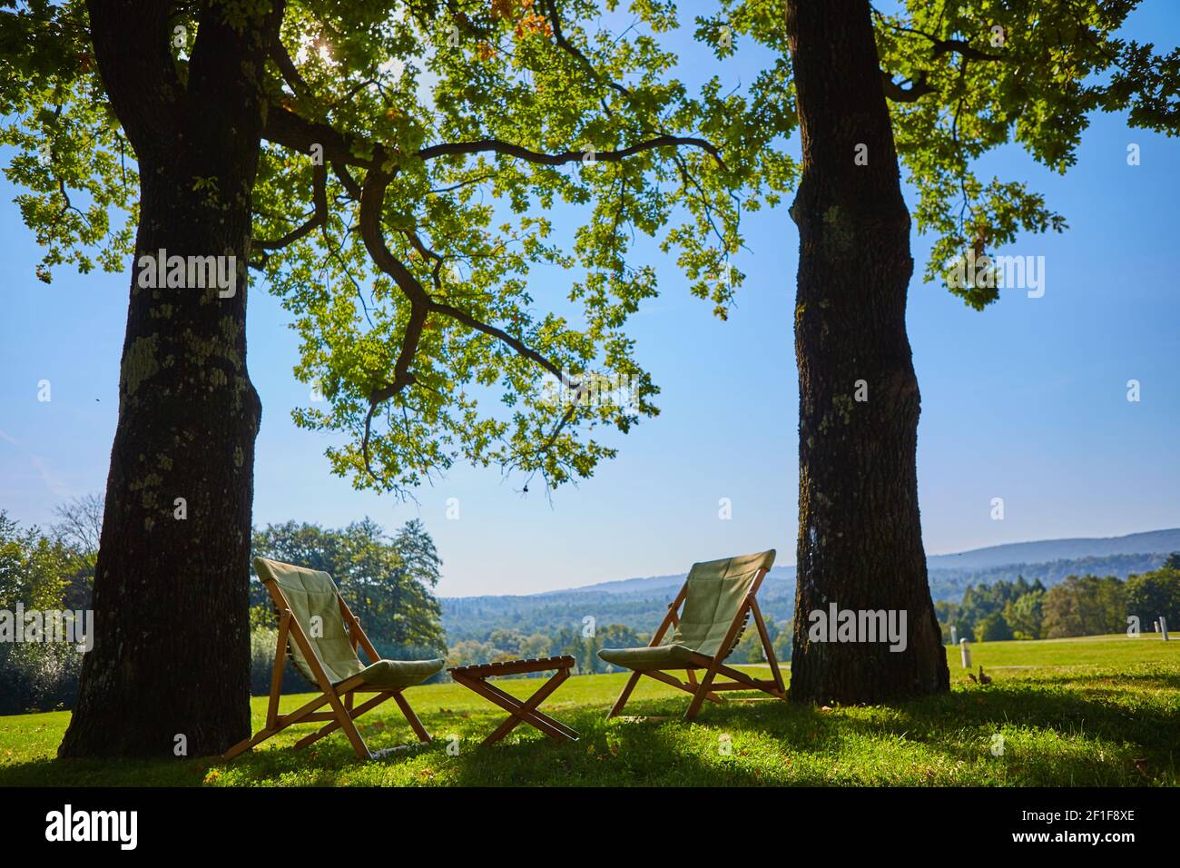 Mit hölzernen Stuhl und Tisch entspannen. Der Blick auf den Garten genießen Stockfoto