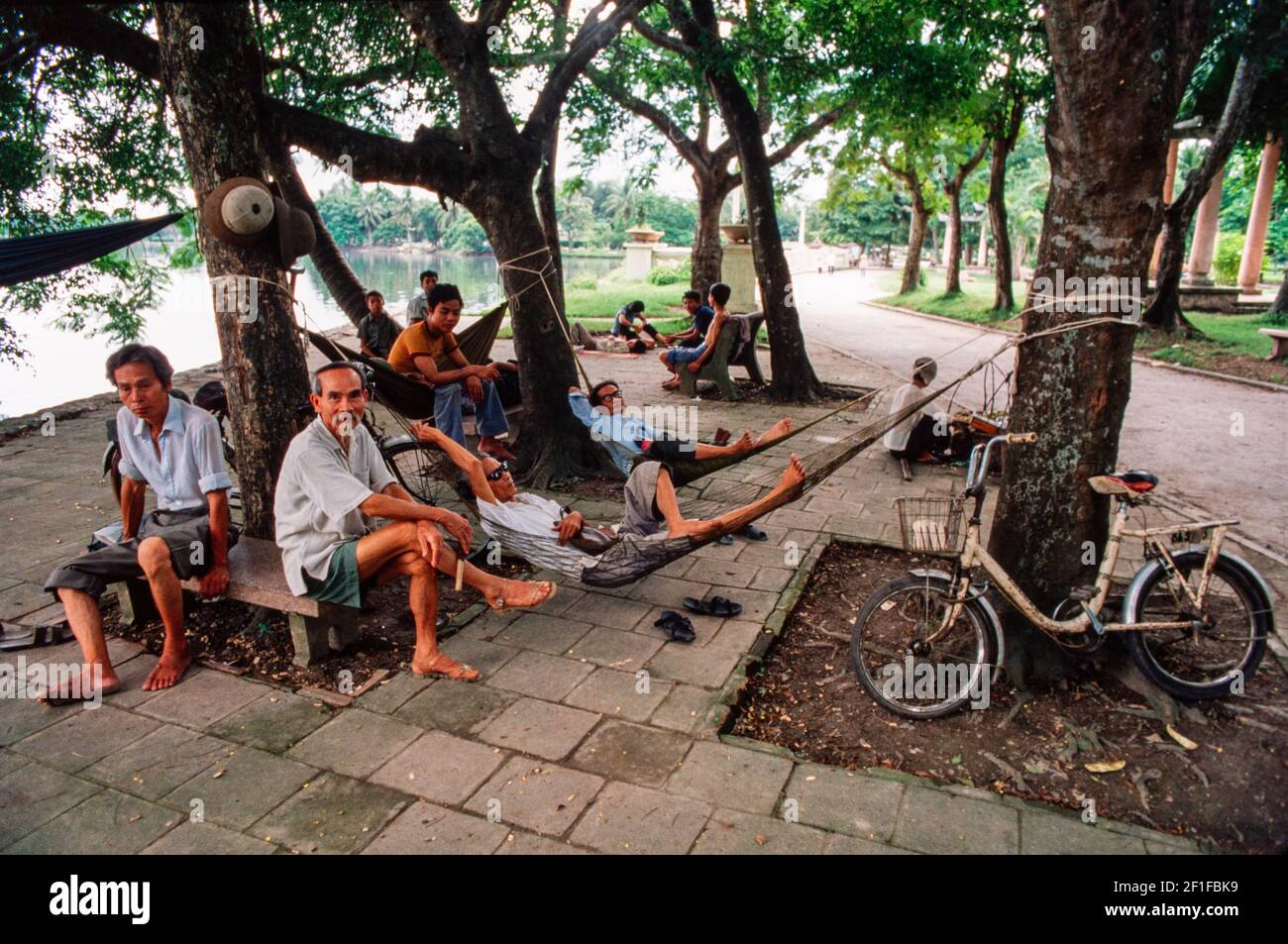 Männer entspannen in ihren Hängematten während der Heaty des Tages am See im Zentrum von Hanoi, Nord-Vietnam, Juni 1980 Stockfoto