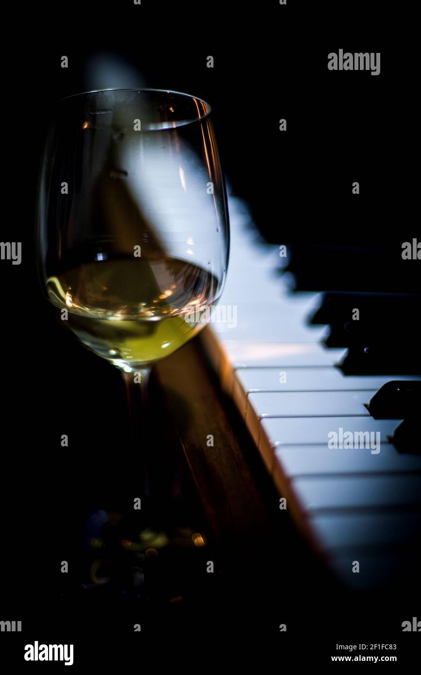 Ein Glas riesling Wein in der Nähe der Klaviertastatur Stockfoto