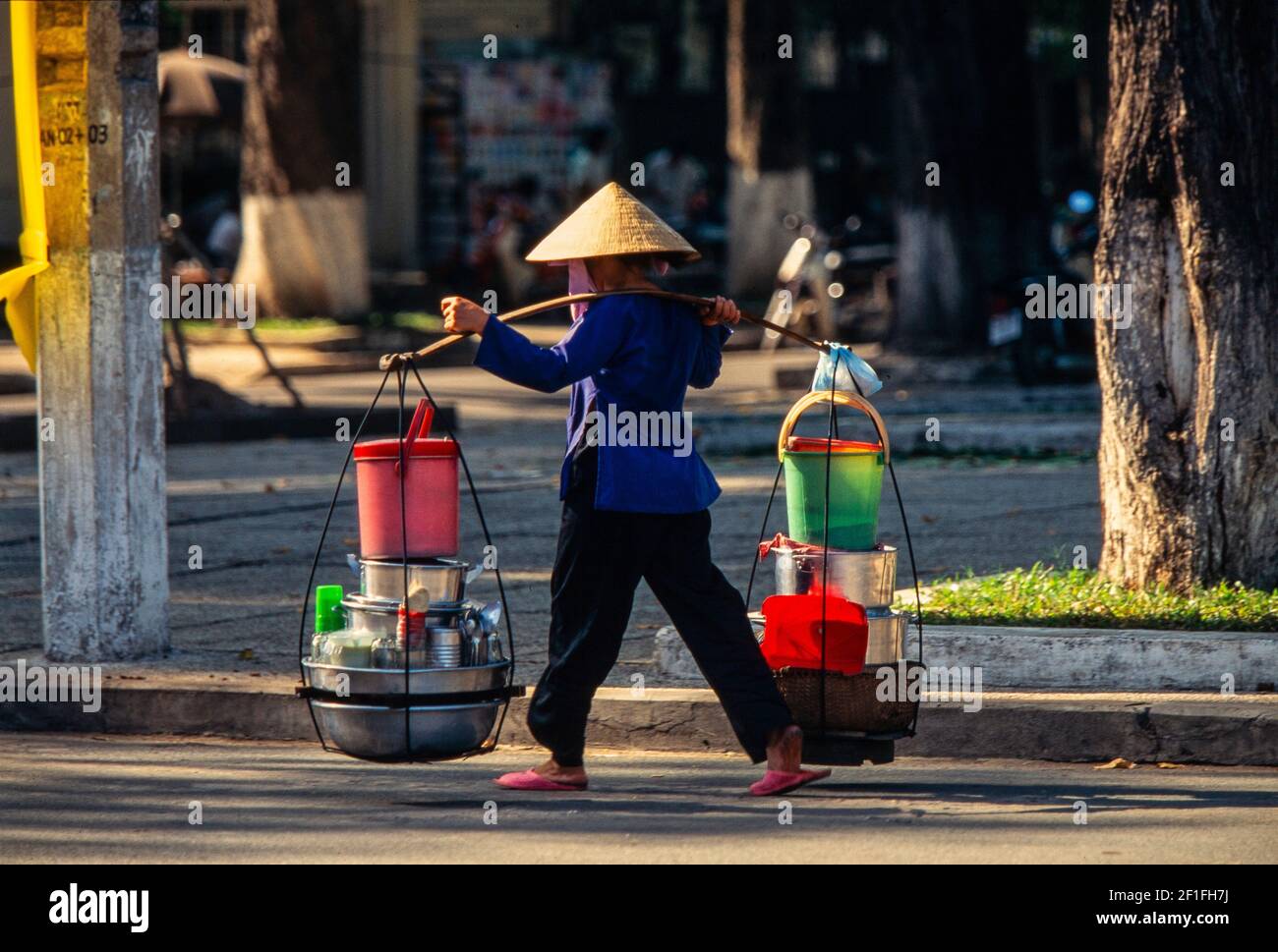 Ein Straßenverkäufer, der alles, was sie für ihren Stand braucht, über ihre Schultern kritscht, Ho Chi Minh City, Oktober 1995 Stockfoto