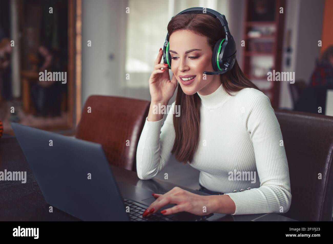 Junge positive Frau mit Headset, die online spricht, Kundensupport Stockfoto