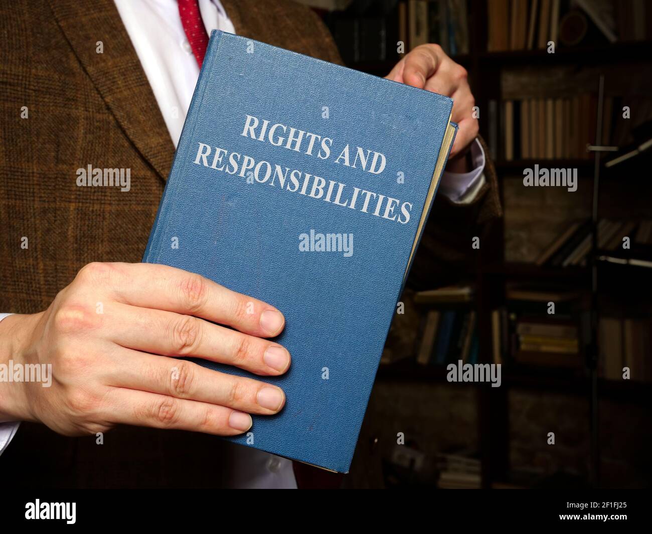 Manager in Suit hält ein Buch mit Rechten und Verantwortlichkeiten. Stockfoto