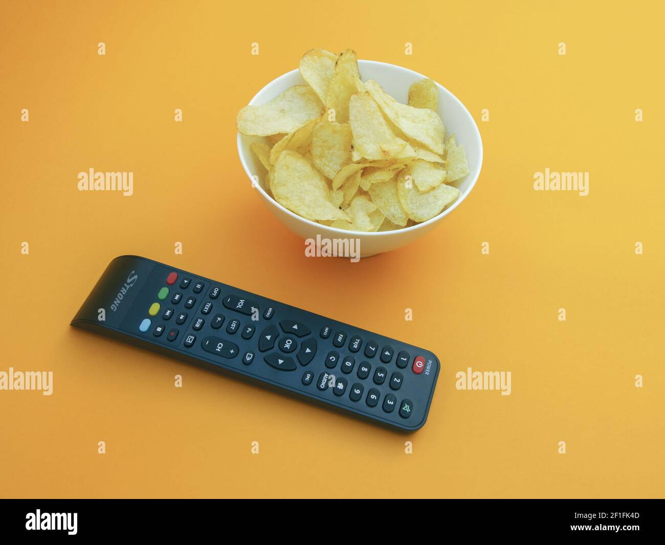 Filme ansehen Konzept mit Chips auf orangenen Hintergrund Foto Stockfoto