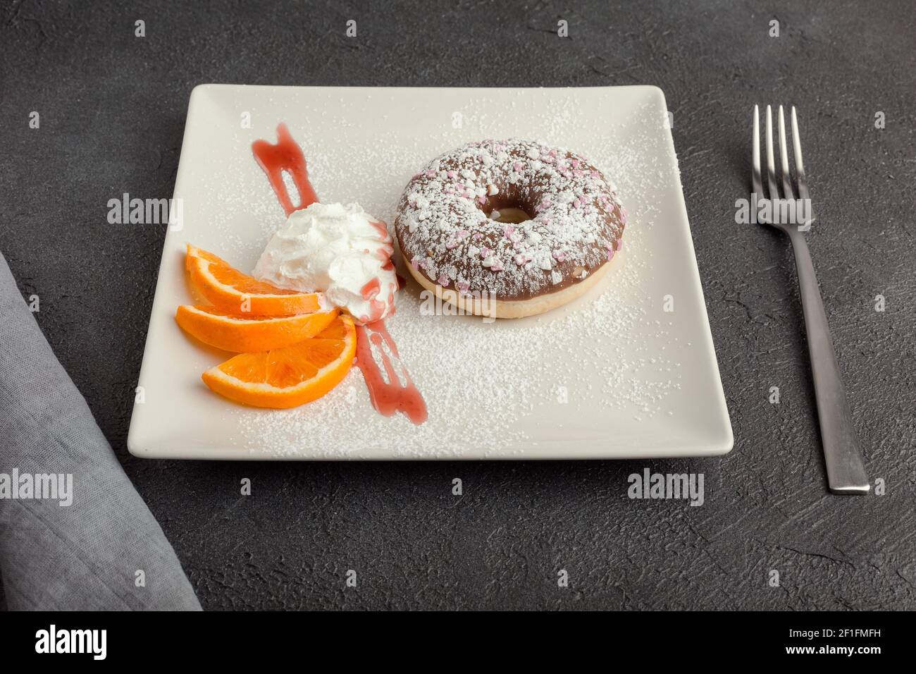 Donut auf Platte isoliert auf schwarzem Hintergrund Stockfoto