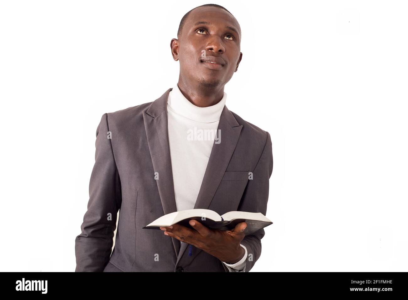 Portrait eines jungen Pastors, der in seiner Hand eine Bibel liest. Stockfoto