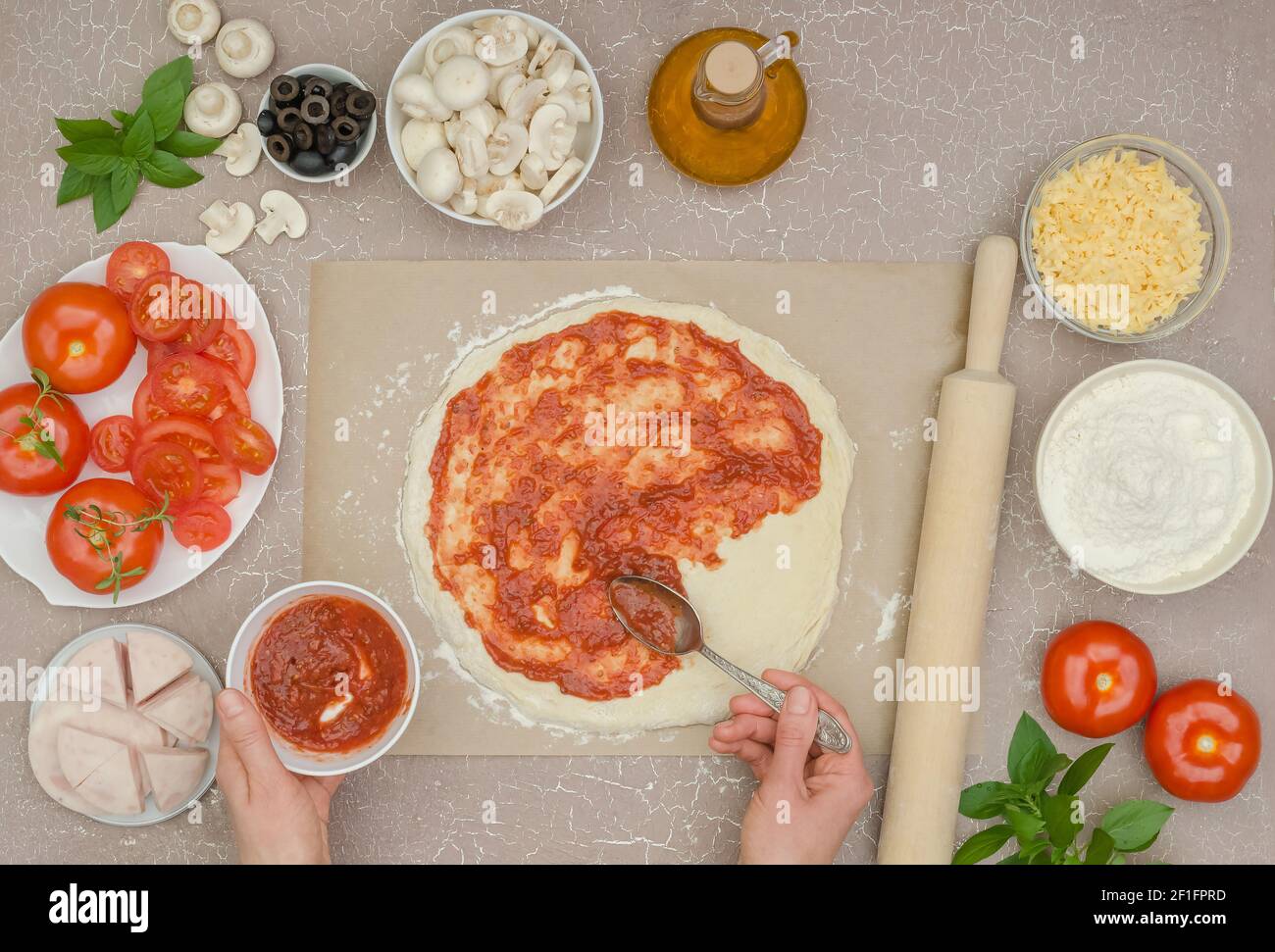 Schritt für Schritt Kochen hausgemachte Pizza mit Schinken, Schritt 4 - Spread the Tomatensauce on the Teig Stockfoto
