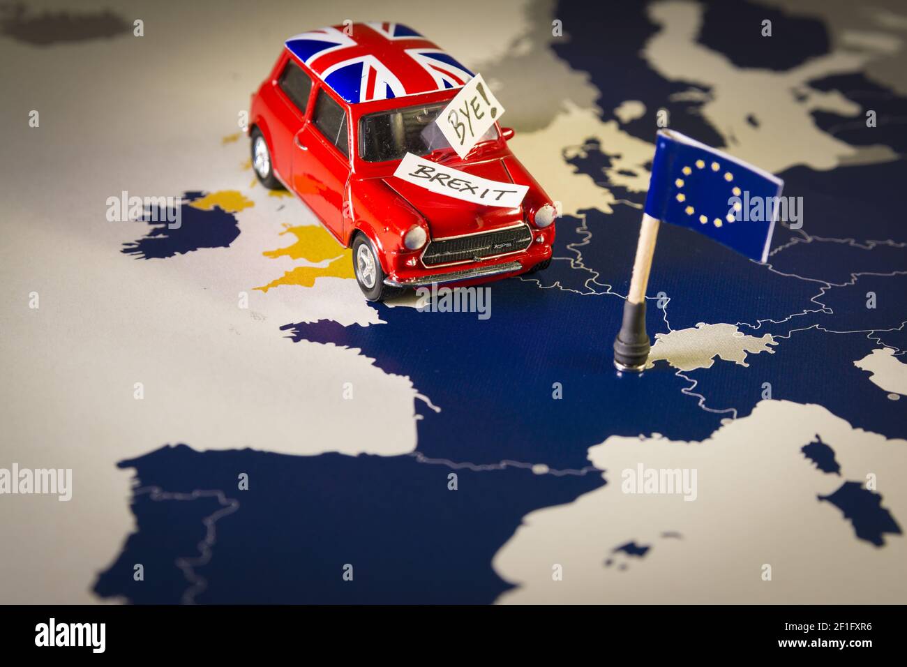 Rote Oldtimer mit Union Jack Flagge und brexit oder bye Worte über eine UE Karte und Flagge. Stockfoto