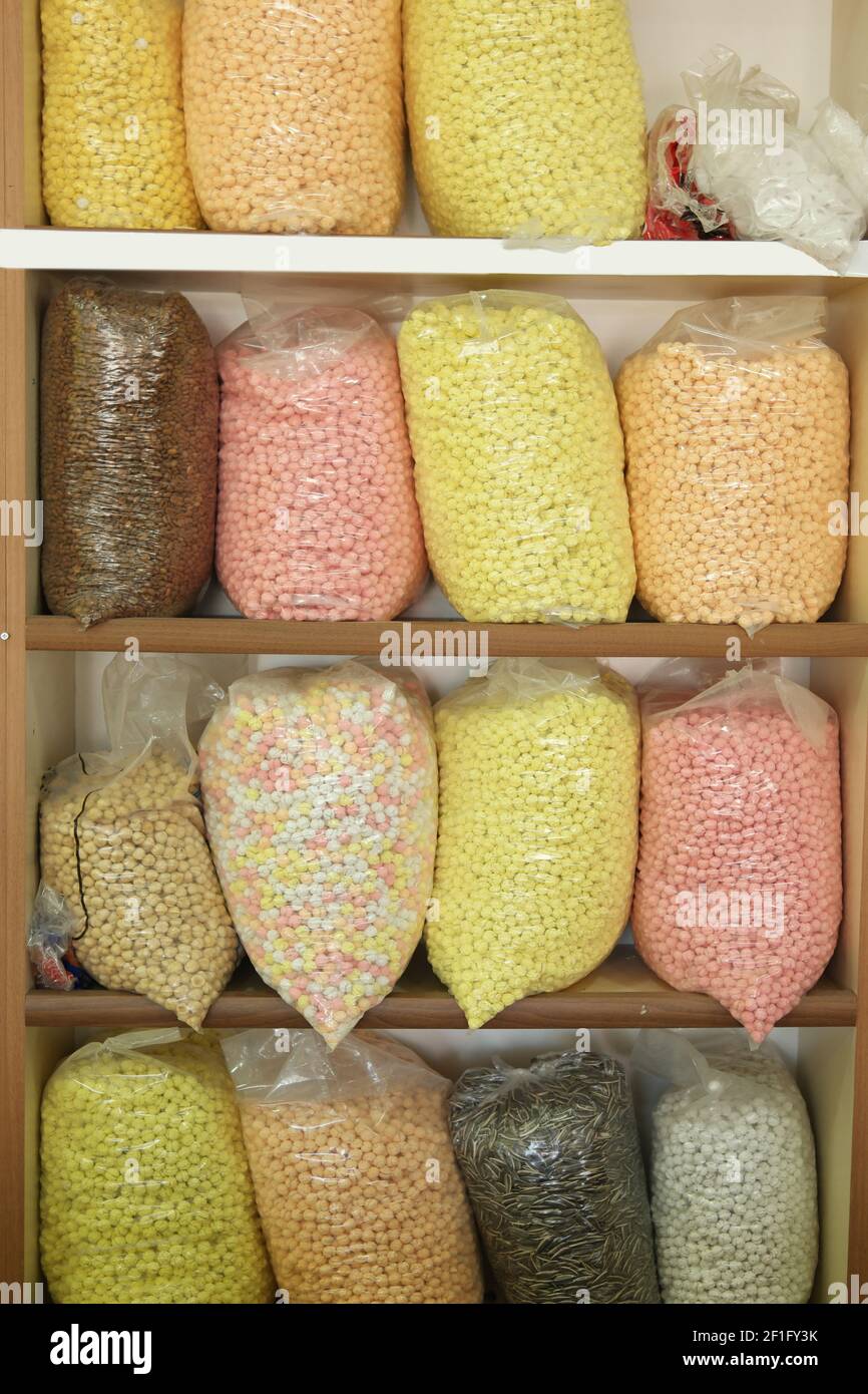 Verschiedene Arten von Hülsenfrüchten und Getreide in Plastiktüten auf dem Regal. Stockfoto