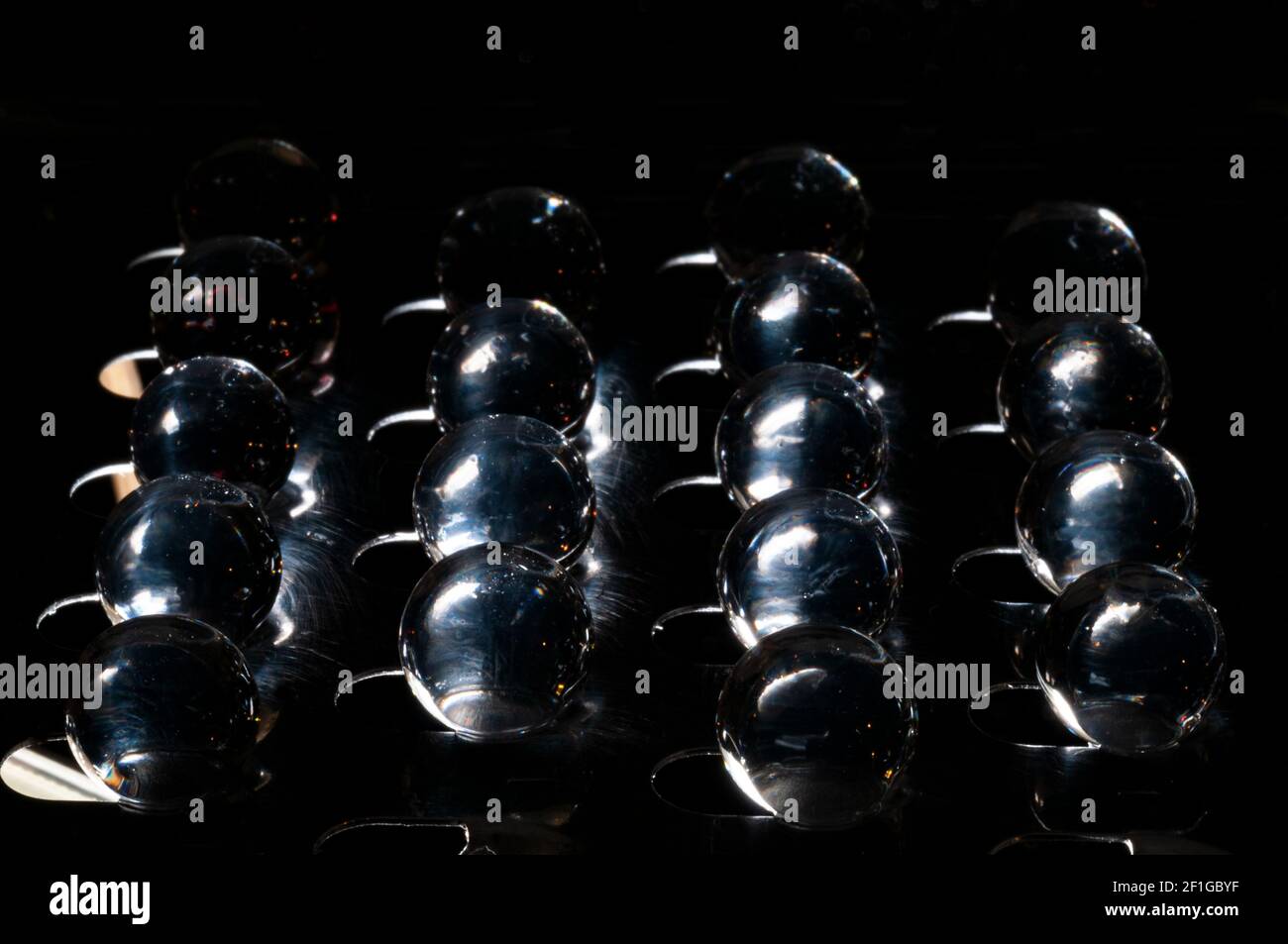 Viele Kugeln im Gleichgewicht auf Inox-Stahlträger Und Hintergrundbeleuchtung Stockfoto